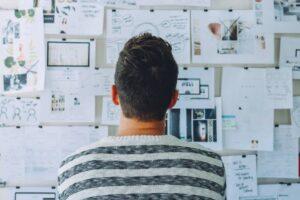 Man staring at a notice board thinking about how to plan